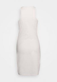 Úzké bezrukávové šaty ve světle béžové barvě, s hladkou texturou a designem sahajícím ke kolenům. Jednoduché, čisté linie, žádné viditelné ozdoby.
