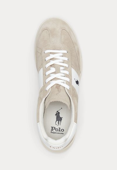Bézs színű szarvasbőr Polo Ralph Lauren tornacipő fehér oldalsávval, fehér fűzőkkel, és fekete pólójátékos logóval a nyelven és a talpbetéten.