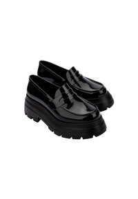 Mocasines de charol negro con una suela de plataforma gruesa, que presentan un detalle de costura y una correa ancha en el empeine.