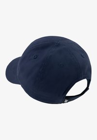 Mornarska kapa za bejzbol s zakrivljenim vizorom, izrađena od teksturirane tkanine. Ima stražnji podesivi remen i ventilacijske rupice.