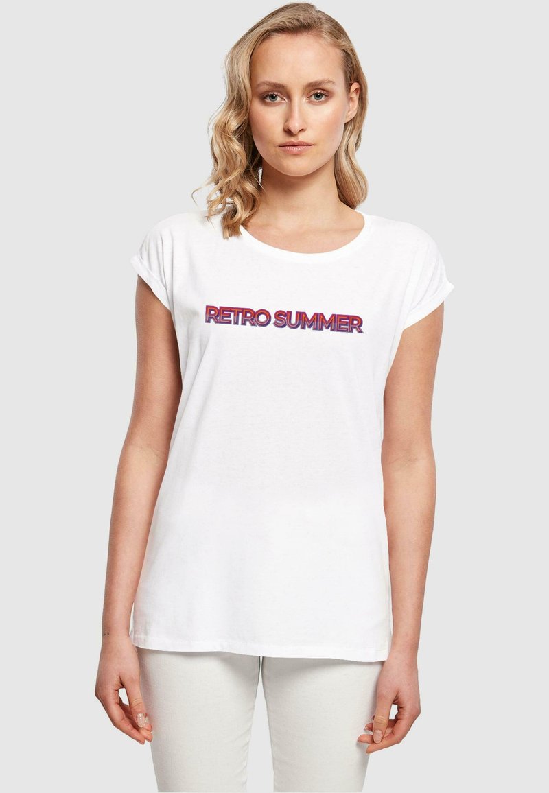 Tricou alb din bumbac cu mâneci rulate și un grafic retro "RETRO SUMMER" în litere îndrăznețe roșii și violet.