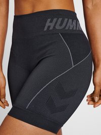 Svarta högmidjade shorts med ribbad textur, med en midja med "HUMAN"-logotyp och en reflekterande detalj på sidan i ett chevronmönster.
