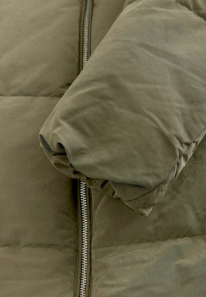 Giacca puffer verde oliva con texture trapuntata, dotata di chiusura con zip e polsini a manica arrotondati. Materiale morbido con finitura liscia.