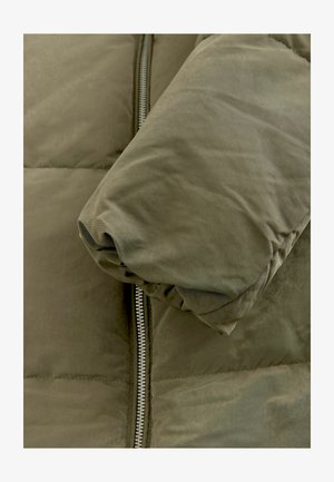 Olijfgroene pufferjack met een quilted textuur, voorzien van een ritssluiting en een afgeronde manchette. Zacht materiaal met een gladde afwerking.
