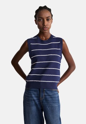 Top sin mangas de punto en color marino con rayas blancas horizontales, cuello redondo, dobladillo acanalado y corte relajado, combinado con unos vaqueros de mezclilla azul.