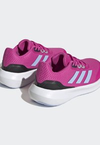 Scarpe sportive in mesh rosa brillante con accenti neri e bianchi. Presentano una parte superiore testurizzata, design con lacci e suola bianca imbottita.