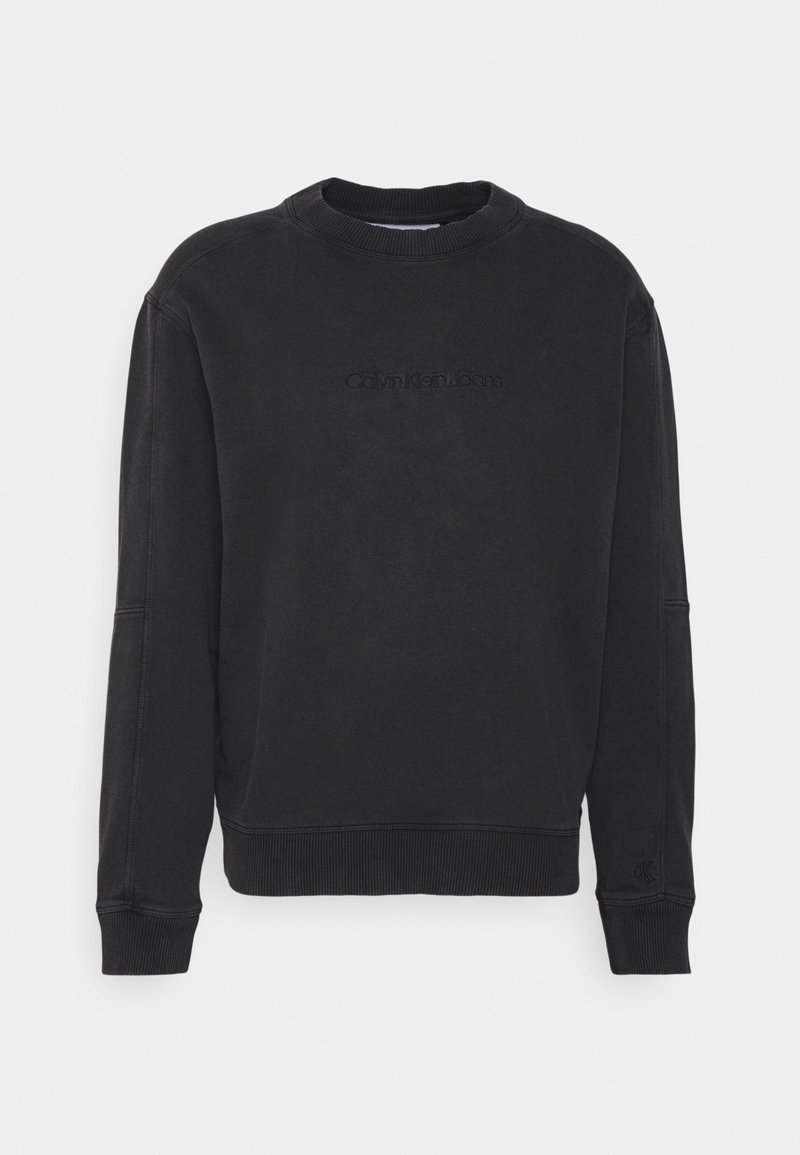 Černá mikina s kulatým výstřihem vyrobená z měkké tkaniny s žebrovanými manžetami a lemem. Na přední straně je vyražené logo "Calvin Klein Jeans". Normální střih.