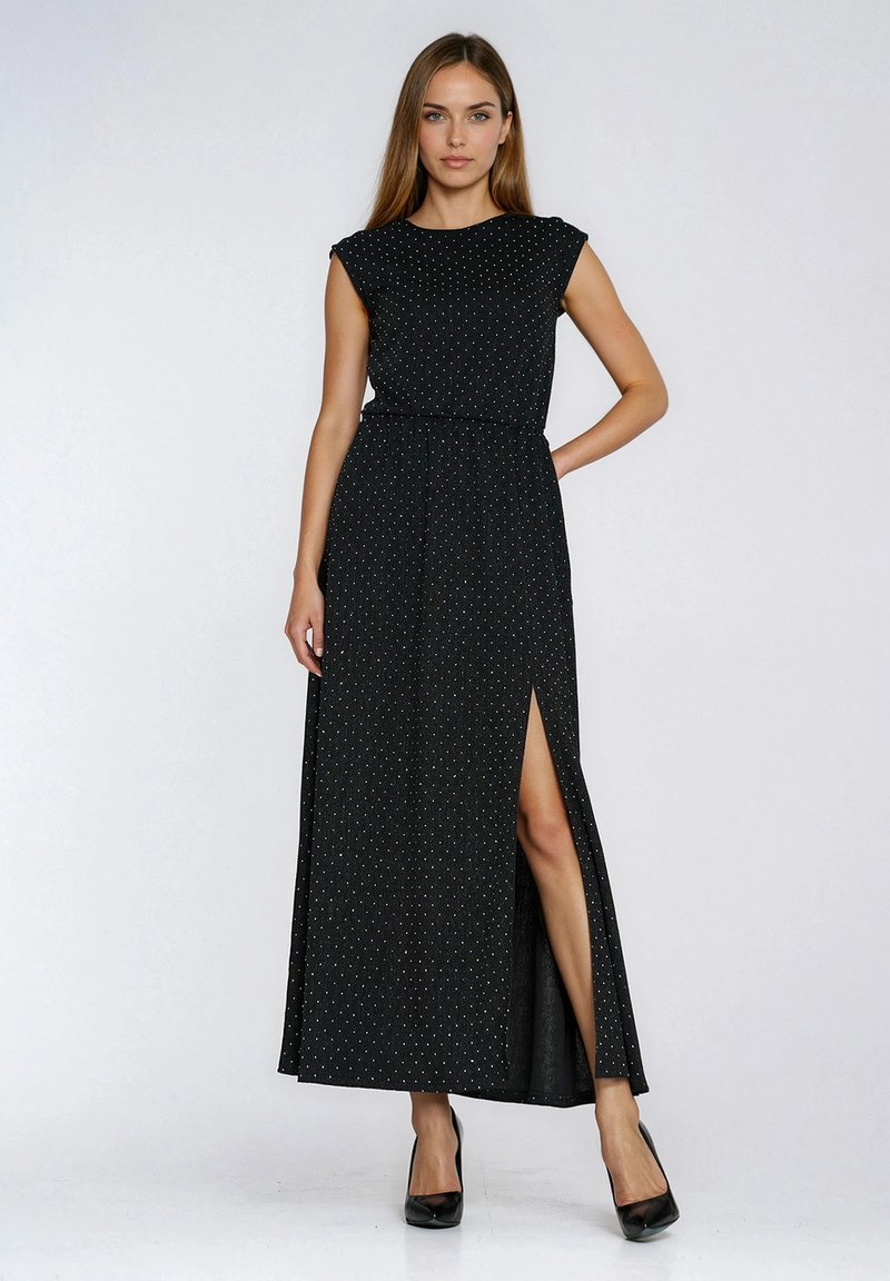 Czarna długa sukienka z krótkimi rękawkami typu kapturek, z wysokim rozcięciem i wzorem białych kropek. Wykonana z lekkiego materiału o gładkiej fakturze.