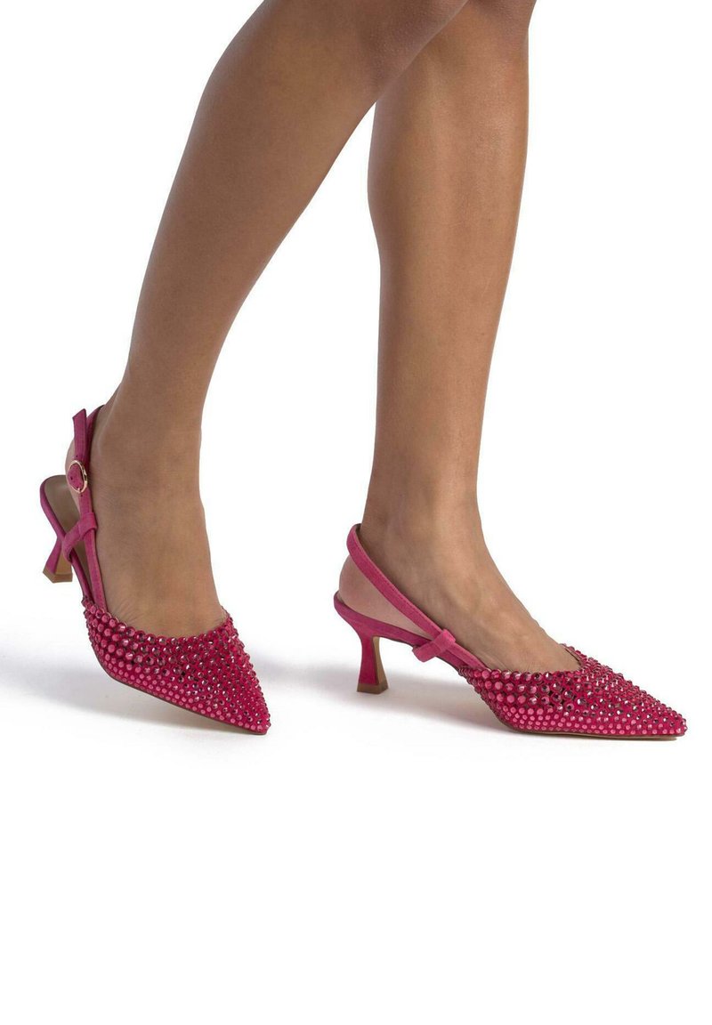 Pink slingback heels with pointed toes, adorned with rhinestones. Material appears textured with a slim, mid-height heel.