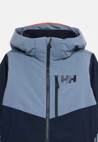 Modra in temna mornarska kapuca jakna z sprednjim zadrgo, žepom na zadrgo na prsih in HH logotipom na desni strani prsnega koša.