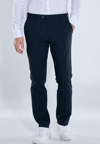 Dark navy trousers with a slim fit design, made from smooth fabric. Features front pockets and subtle branding on the waistband.