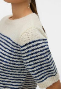 Pull en tricot avec un motif rayé crème et bleu marine, encolure ronde et manches courtes, en tissu doux et texturé.