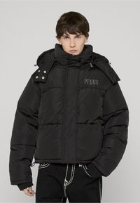 Črna puhovka z visokim ovratnikom, s prešitim dizajnom, sprednjim zadrgo in izvezenim logotipom "PEOUS". Strukturiran material in podrobnosti.