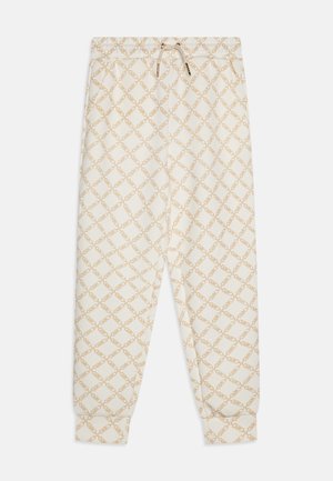 Pantalones de chándal color crema con un patrón de cadena en forma de diamante, cinturilla elástica con cordón y puños acanalados en los tobillos.