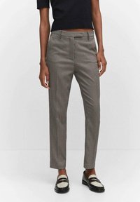 Spodnie w kant w czarno-białą pepitkę, o dopasowanym kroju, z płaskim przodem i kieszeniami po bokach. Gładki materiał, elegancki design.