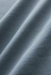 Tela azul clara que muestra una textura suave con suaves pliegues. El material parece suave y uniforme sin patrones o acentos visibles.