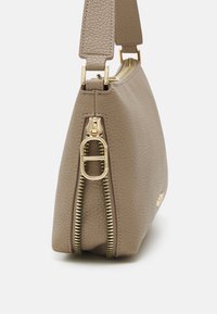 Beige leren tas met een gestructureerde afwerking, gouden ritsdetails en een verstelbare schouderriem. Compact, met een gestructureerde silhouet en een minimalistisch ontwerp.