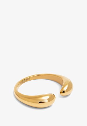 Bracelet en métal doré avec une finition lisse et polie, et des extrémités arrondies. Le design présente une forme moderne et minimaliste.