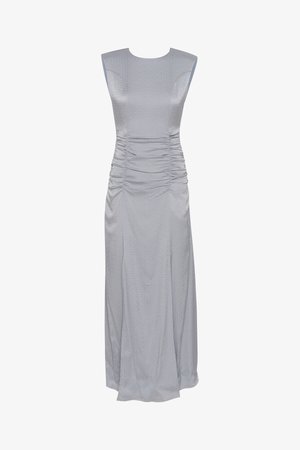 Sivi brezrokavni plašč z teksturirano površino, naborki na straneh in dolga, tekoča silhueta.