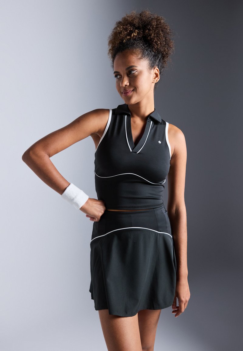 Schwarzes Sportoutfit bestehend aus einem ärmellosen Poloshirt und einem Rock, akzentuiert mit weißen Rändern. Glatte Textur mit enganliegendem Design für aktive Nutzung.