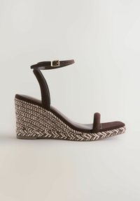 Sandală cu platformă maro, cu bază țesută texturată, baretă reglabilă la gleznă și talpă interioară din piele întoarsă netedă; design cu vârf deschis și stil minimalist.