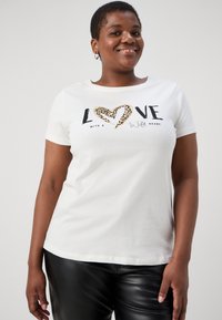 Bílé tričko s krátkým rukávem a grafickým designem, na kterém je slovo "LOVE" a srdce s leopardím potiskem. Měkký bavlněný materiál a přiléhavý střih.