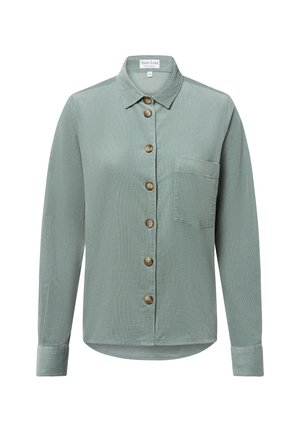 Camicia verde chiaro con bottoni, realizzata in tessuto texturizzato. Caratterizzata da un colletto, maniche lunghe e una tasca sul petto con bottoni di legno.