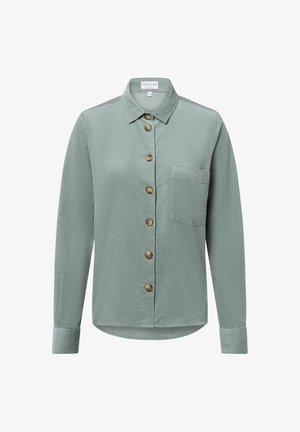 Light green button-up shirt made of textured fabric. Features a collar, long sleeves, and a chest pocket with wooden buttons.