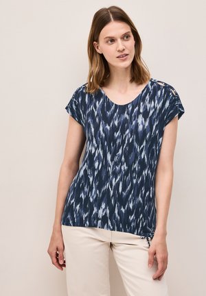 T-shirt bleu marine à manches courtes avec un motif d'ondes abstrait en bleu clair, un col rond et des liens latéraux ajustables. Texture de tissu lisse.