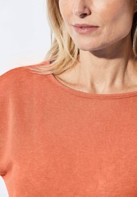 Roestkleurig, T-shirt met korte mouwen en een ronde hals, gemaakt van een gladde stof, met een ontspannen pasvorm en subtiele stikdetails.
