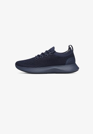 Sneaker in tessuto a maglia blu scuro con lacci frontali, suola spessa imbottita e linguetta sul tallone, vista laterale.