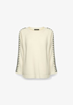 Suéter color crema de manga larga con detalles de puntadas en forma de cadena de color gris oscuro que recorren los brazos exteriores.