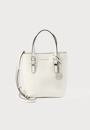 Hvit Michael Kors skinnveske med doble håndtak, justerbar skulderrem og rund metall MK-logo charm.