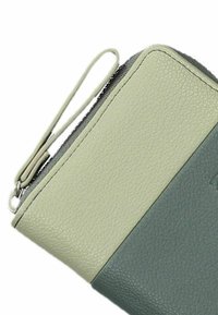 Portafoglio in pelle verde e verde chiaro con superficie testurizzata, chiusura con zip e una cinghia ad anello per un facile trasporto.