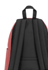 Černý a korálový batoh se polstrovanými popruhy, texturovanou tkaninou a bočními kapsami. Obsahuje horní uchopovací rukojeť a zipem uzavíratelnou přihrádku.