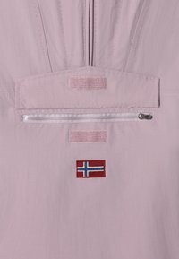 Tessuto rosa chiaro con una superficie liscia. Caratterizzato da una tasca verticale con zip e un patch ricamato della bandiera norvegese. Accenti in Velcro sopra la zip.