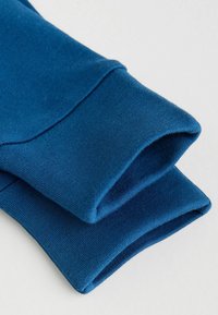 Blue cotton sweatshirt cuffs with a smooth texture and stitched edges, showcasing a folded design and clean finish.