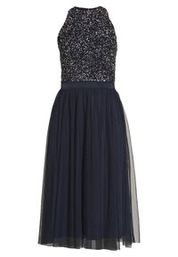 Laivastonsininen mekko, jossa on olkaimeton helmillä koristeltu yläosa ja tyllihame. Mekossa on vyötämyksiin istuva malli sekä ilmava, kerroksellinen muotoilu, joka lisää volyymia.