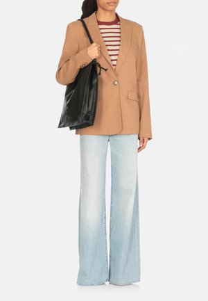 Blazer marrone con revers a vista, chiusura a un bottone. Maglietta a righe bordeaux e bianca, jeans svasati blu chiaro e una borsa a tracolla in pelle nera.