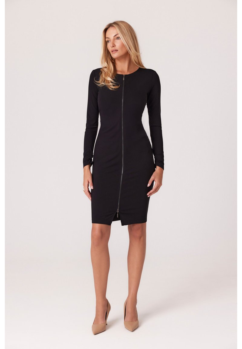 Czarna sukienka z długim rękawem, zapinana z przodu na zamek, dopasowana, do kolan, wykonana z elastycznego materiału, z wyraźnymi szwami i wysokim dekoltem.