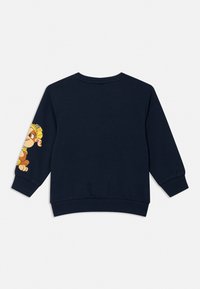 Felpa blu navy con maniche lunghe, polsini a coste e una grafica di un personaggio dei cartoni animati in giallo e marrone sulla manica sinistra.