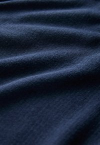 Tengerészkék texturált szövet sima felülettel, finom árnyalatváltozásokkal és puha, szőtt megjelenéssel.