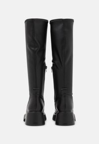 Botas negras hasta la rodilla hechas de cuero texturizado, con un diseño elegante, punteras redondeadas y tacones gruesos con cremalleras traseras.