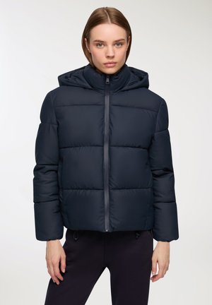 Giacca puffer blu navy con cappuccio e chiusura con zip, caratterizzata da un design trapuntato e polsini elastici per calore e comfort.