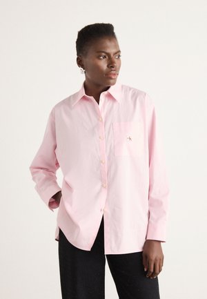 Lichtroze overhemd met lange mouwen en button-down kraag, voorzien van een borstzak en geborduurd logo. Gemaakt van gladde katoenstof.