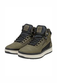 Zapatilla alta en verde oliva y negro, con un upper de cuero suave, detalles de malla, ojales reforzados y una gruesa suela de goma blanca.