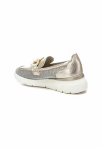 Zapato slip-on metálico dorado con detalles de malla, un lazo decorativo y suela blanca. El diseño presenta una textura suave y forma redondeada.