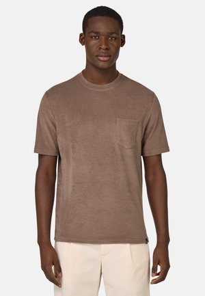 Braunes Baumwoll-T-Shirt mit rundem Halsausschnitt und kurzen Ärmeln. Verfügt über eine aufgesetzte Tasche auf der linken Brust und hat eine weiche, strukturierte Oberfläche.