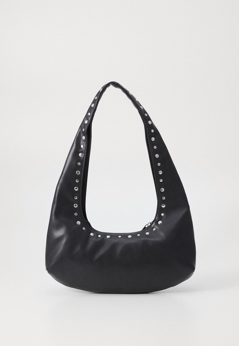 Sac à bandoulière en cuir noir avec des clous ronds argentés le long de la sangle et du bord supérieur, sur un fond clair uni.