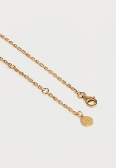 Χρυσό κολιέ με μικρό στρογγυλό κούμπωμα και κυκλικό μενταγιόν με σφραγίδα "AL" σε λευκό φόντο.